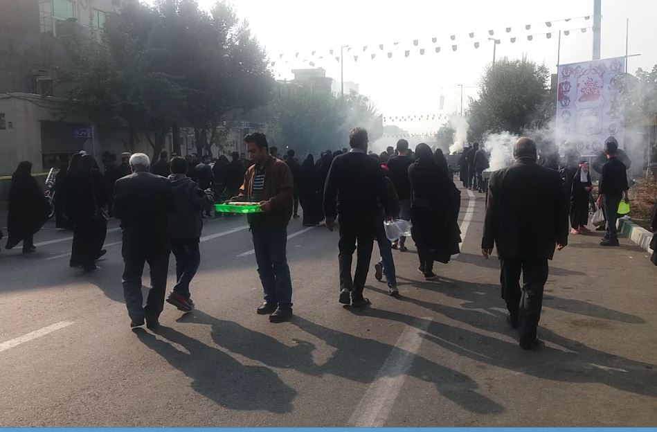  خادم الحسین مرتضی قوامی در حال توزیع شربت در میان راهپیمایان مراسم جاماندگان حسینی تهران است. 